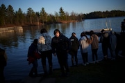 Young members of the Lac du Flambeau Band of Lake Superior Chippewa Indians line up to put tobacco in the lake as an offering during a youth spearfishing event on the Lac du Flambeau Reservation, Saturday, April 20, 2024, in Lac Du Flambeau, Wis. (AP Photo/John Locher)