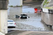 Buffalo Bayou floods, stranding vehicles near downtown Houston after Beryl came ashore in Texas as a hurricane and dumped heavy rains downtown. (AP Photo/Maria Lysaker)