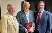 Luke Hallmark, center, was recognized by new Alabama High School Athletic Association Central Board of Control president Terry Curtis, left, and AHSAA executive director Heath Harmon at the board's meeting in Montgomery on Wednesday, July 24, 2024. Hallmark retired from the board and as superintendent of Marengo County Schools.